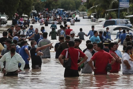 Người dân Honduras di chuyển trên tuyến đường bị ngập. (Ảnh: AP)