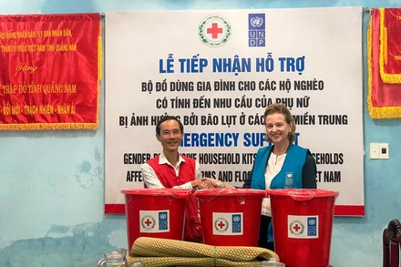 Bà Caitlin Wiesen trao đồ hỗ trợ cho người dân vùng bị ảnh hưởng bão lụt.