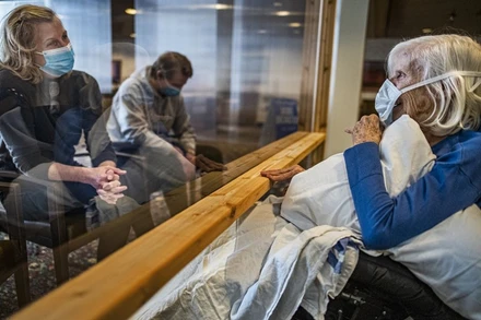 Khách đến thăm người thân tại nhà dưỡng lão Jones-Harrison Residence ở TP Minneapolis, Mỹ, phải đeo khẩu trang và có vách ngăn khi trò chuyện. (Ảnh: AP)