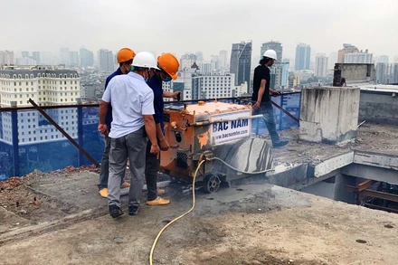 Lực lượng chức năng xử lý vi phạm tại tầng 18 công trình số 8B phố Lê Trực.  