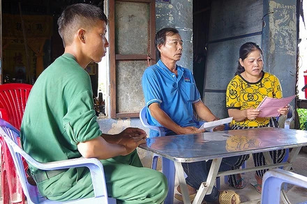 Bà Danh Thị Bé Tư (áo vàng), mẹ quân nhân Huỳnh Thanh Hiếu (Trung đoàn 20, Sư đoàn 330, Quân khu 9) đọc thư của đơn vị gửi trong thời gian con mình được nghỉ phép.