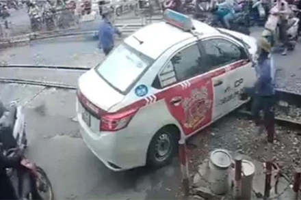 Xe taxi do tài xế Ngô T. L điều khiển vượt rào chắn đường ngang khi chắn đang dịch chuyển. (Ảnh: CAND)