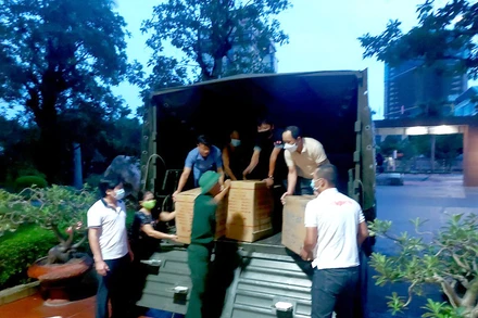 Cán bộ, phóng viên Báo Nghệ An bốc hàng lên xe hỗ trợ người dân 2 bản La Ngan, Lưu Tiến.