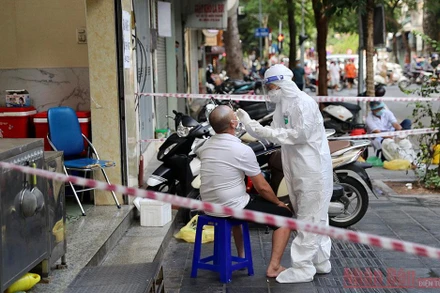 Lấy mẫu xét nghiệm cho người dân tại khu vực phong tỏa ở Hà Nội. Ảnh: DUY LINH