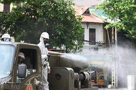 Các lực lượng chức năng phun hóa chất khử khuẩn tại khu vực phố cổ Hà Nội. (Ảnh: DUY LINH)