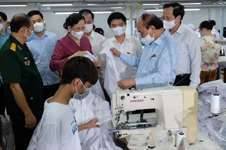 Ngày 23/7, Chủ tịch nước Nguyễn Xuân Phúc đến thăm doanh nghiệp may mặc Hoàng Tuyên tại tỉnh Hà Nam, do thương binh làm kinh tế giỏi Hoàng Văn Tuyên làm chủ. (Ảnh: Đào Phương)