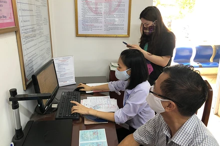 Cán bộ phường Ngọc Lâm (quận Long Biên, Hà Nội) hỗ trợ công dân thực hiện dịch vụ công trực tuyến trên mạng internet. (Ảnh: ĐĂNG ANH)