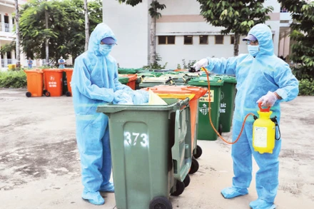 Công nhân Công ty Môi trường đô thị tiến hành khử khuẩn rác thải y tế liên quan dịch Covid-19.