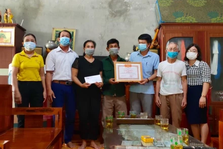 Lãnh đạo xã Đặng Sơn trao giấy khen và tiền thưởng cho vợ chồng ông Ngô Văn Nam. 