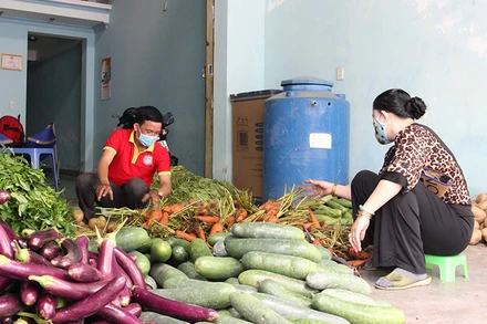 Anh Nguyễn Ngọc Bình (áo đỏ) chuẩn bị rau củ hỗ trợ người dân.