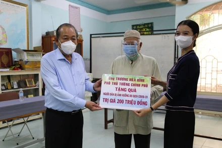 Phó Thủ tướng Thường trực Chính phủ Trương Hòa Bình và đại diện đơn vị tài trợ trao bảng tượng trưng, tặng quà cho ông Kim Sô, Giáo cả Thánh đường Anwar.