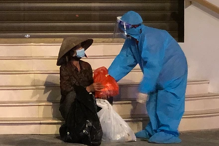 Tình nguyện viên “Bữa cơm nghĩa tình - Vượt qua đại dịch” mang thực phẩm đến hỗ trợ người có hoàn cảnh khó khăn trong đêm.