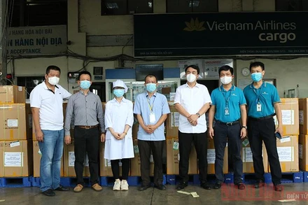 Đại diện Công ty Medicon, đại diện Báo Nhân Dân và Hãng hàng không Vietnam Airlines chuyển bộ kit xét nghiệm vào TP Hồ Chí Minh. 