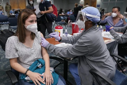 Cô Natalia Dubom (Honduras) được tiêm vaccine ngừa Covid-19 khi tới Sân bay quốc tế Miami, tại Miami, Mỹ. (Ảnh: AP)