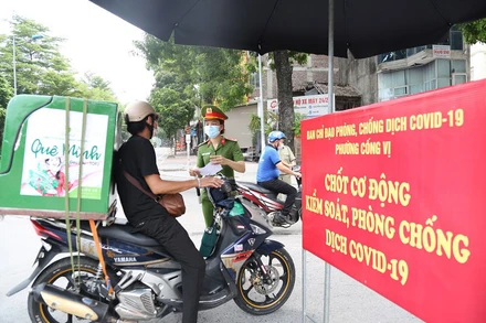 Lực lượng chức năng phường Cống Vị, quận Ba Đình kiểm tra giấy tờ tùy thân tại chốt kiểm soát dịch Covid-19 trên phố Đội Cấn. (Ảnh: THANH HẢI)