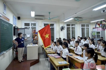 Lễ chào cờ đầu tuần diễn ra trong lớp học thay vì tập trung ở sân trường, của học sinh tiểu học. Ảnh: DUY LINH