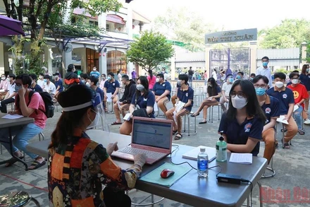 Học sinh đăng ký thông tin trước khi tiêm vaccine phòng Covid-19. (Ảnh: THIÊN VƯƠNG)