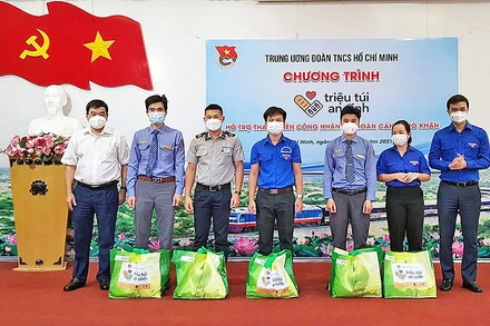 Đồng chí Bùi Quang Huy (ngoài cùng bên phải) trao “Túi an sinh” tặng đại diện thanh niên công nhân có hoàn cảnh khó khăn.