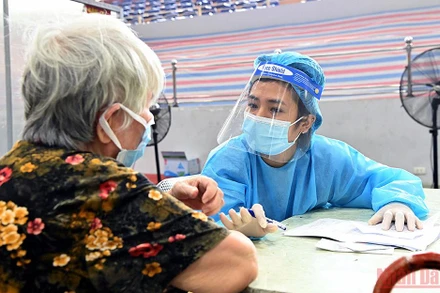 Nhập thông tin trước khi tiêm cho người cao tuổi ở Hà Nội. (Ảnh: DUY LINH)