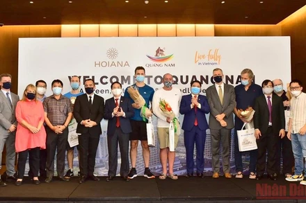 Phó Chủ tịch UBND tỉnh Quảng Nam Trần Văn Tân tặng hoa chúc mừng đại diện đoàn khách quốc tế đầu tiên đến Quảng Nam. (Ảnh: TẤN NGUYÊN)