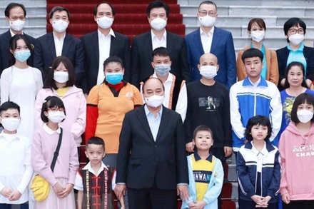 Chủ tịch nước Nguyễn Xuân Phúc với các học sinh xuất sắc trong cuộc thi vẽ tranh và sáng tác văn học "Vì một Việt Nam tất thắng". (Ảnh: Thống Nhất/TTXVN)