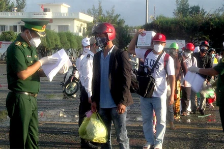 Cán bộ, chiến sĩ Đồn Biên phòng cửa khẩu Cảng Phú Quý kiểm tra, kiểm soát hành khách theo quy định phòng, chống dịch Covid-19 trước khi lên tàu vào đất liền. (Ảnh: BĐBP Bình Thuận).