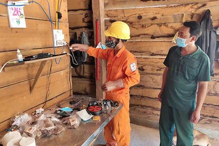 Công nhân Công ty Điện lực Kon Tum hướng dẫn cho người dân làng Dao, xã Ia Dom, huyện Ia H’Drai cách sử dụng điện an toàn. 