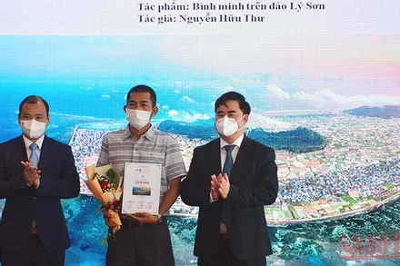 Ông Lê Hải Bình (bên trái) và PGS, TS Phạm Minh Tuấn trao giải nhất cho tác phẩm "Bình minh trên đảo Lý Sơn" của tác giả Nguyễn Hữu Thư.
