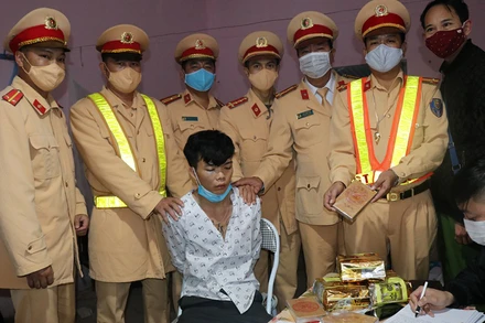 Tòng Văn Dính cùng tang vật khi bị lực lượng Cảnh sát giao thông Công an tỉnh Điện Biên bắt giữ.