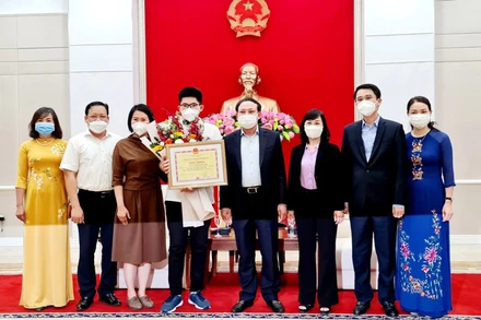 Đồng chí Nguyễn Xuân Ký trao tặng Bằng khen cho em Nguyễn Hoàng Khánh, quán quân Đường lên đỉnh Olympia lần thứ 21.