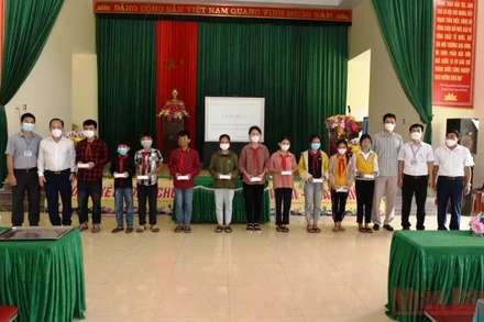 Đại diện lãnh đạo huyện Quỳ Hợp và phóng viên Báo Nhân Dân thường trú tại Nghệ An trao điện thoại thông minh cho các cháu học sinh nghèo hiếu học. 
