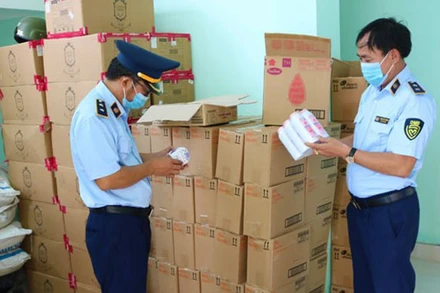 Cán bộ quản lý thị trường Quảng Bình kiểm tra số hàng hóa có dấu hiệu nhập lậu bị thu giữ.