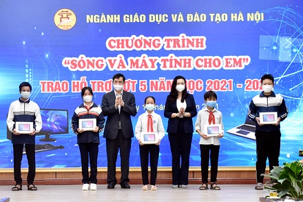 Các Phó giám đốc Sở: Phạm Xuân Tiến, Trần Lưu Hoa trao máy tính cho đại diện các em học sinh có hoàn cảnh khó khăn huyện Ba Vì.