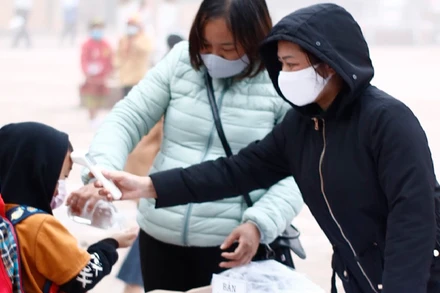 Mỗi học sinh Trường Phổ thông Dân tộc bán trú Trần Văn Thọ đều cô giáo đo thân nhiệt, hướng dẫn sát khuẩn tay trước khi vào trường.