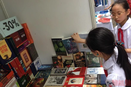 Xây dựng văn hóa đọc sâu rễ bền gốc từ lứa tuổi nhỏ là nhiệm vụ quan trọng. (Ảnh: Các em học sinh tham khảo sách tại khu trưng bày nhân Ngày Sách Việt Nam của Thư viện Quốc gia)