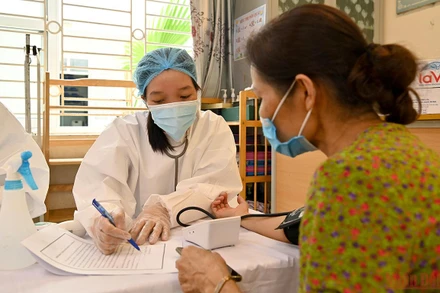 Khám sàng lọc trước khi tiêm cho người dân tại phường Gia Thụy, quận Long Biên. (Ảnh: DUY LINH)