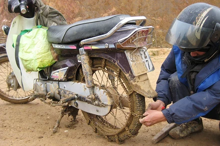 Để đi được trong mùa mưa, xe máy của các thầy cô giáo phải cuốn thêm xích.