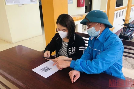 Hướng dẫn người dân quét mã QR tại bộ phận tiếp nhận và trả kết quả UBND Bảo Sơn, huyện Lục Nam.