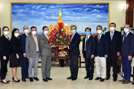 Đại sứ Nguyễn Bá Hùng (trái) chúc mừng và đánh giá cao những thành tựu phát triển kinh tế-xã hội mà Lào đạt được trong 46 năm qua. (Ảnh: Đại sứ quán Việt Nam tại Lào)