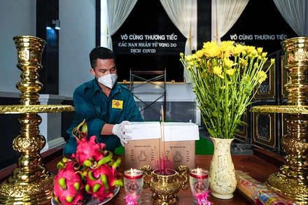 Một chiến sĩ dân quân tự vệ thắp hương cho một nạn nhân tử vong trong dịch Covid-19. Ảnh: Hoàng Triều.