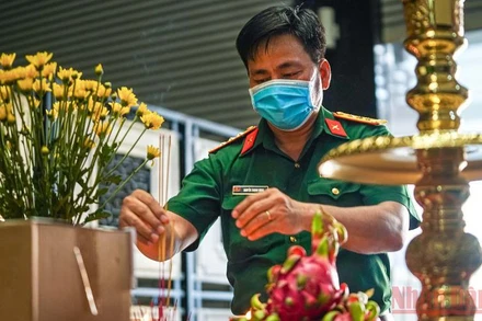 Cán bộ thuộc Bộ Tư lệnh thành phố Hồ Chí Minh thắp hương cho các nạn nhân tử vong vì Covid-19. (Ảnh: HOÀNG TRIỀU)