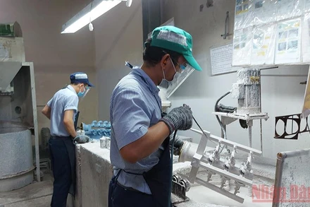 Công nhân sản xuất ổn định trở lại tại doanh nghiệp đóng trong Khu chế xuất Tân Thuận, quận 7. 