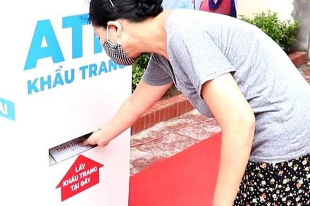 Người dân chờ đợi đến lượt lấy khẩu trang.