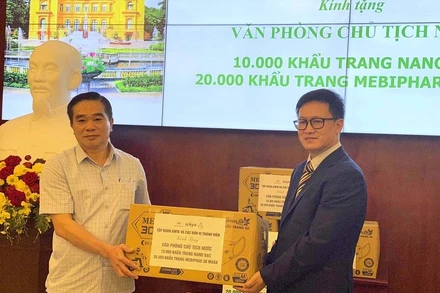 Đồng chí Lê Xuân Khánh, Phó Bí thư Đảng ủy, Quyền Vụ trưởng Vụ Quản trị - Tài vụ, Văn phòng Chủ tịch nước (bìa trái) tiếp nhận khẩu trang do đại diện Công ty Mebiphar - Aikya Pharma trao tặng.