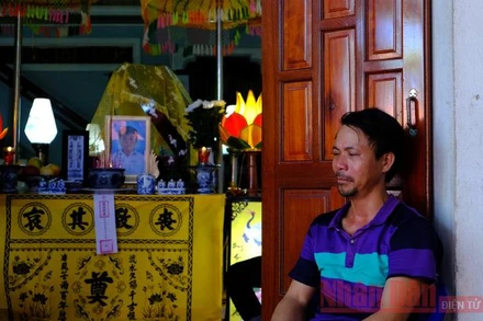 Ông Đặng Minh Vương thẫn thờ bên di ảnh của con là cháu Đặng Minh Nhật.