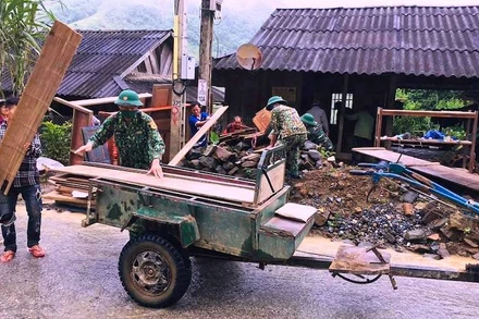 Bộ đội biên phòng trợ giúp hộ dân vận chuyển đồ dùng, vật dụng đến nơi ở mới.