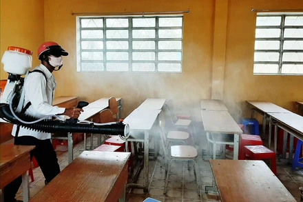 Phun thuốc khửng trùng trong các phòng thi ở Sóc Trăng. (Ảnh: XUÂN LƯƠNG)