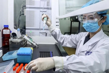 Một nhân viên đang thử nghiệm các mẫu vaccine Covid-19 tiềm năng tại nhà máy sản xuất của Sinopharm ở Bắc Kinh, Trung Quốc ngày 11-4. Ảnh: Tân Hoa xã.