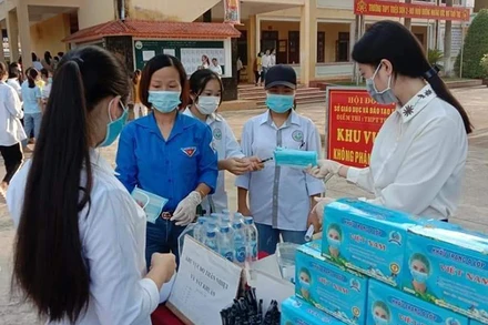 Cấp phát khẩu trang cho thí sinh trước khi dự thi tốt nghiệp THPT quốc gia.