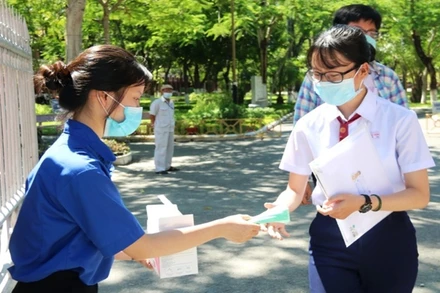 Thanh niên tình nguyện phát khẩu trang cho thí sinh ngay tại cổng vào các điểm thi.